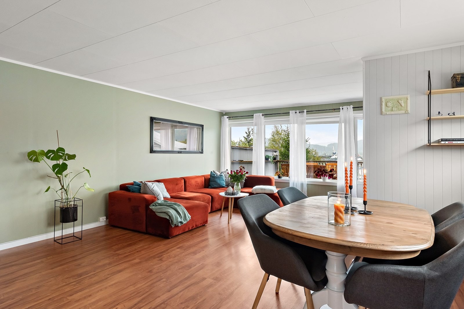 Veggen mellom tv-seksjon og spisebord skaper en naturlig romdeler for de ulike sonene i stua. Galleribilde