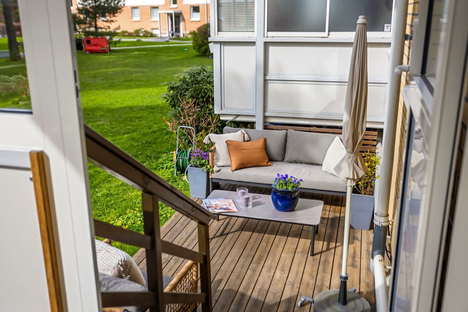 Fra balkongen er det trapp ned til terrasseplatting på 10 m² og direkte adkomst til gressplen. Her får man fort rekkehusfølelse Galleribilde