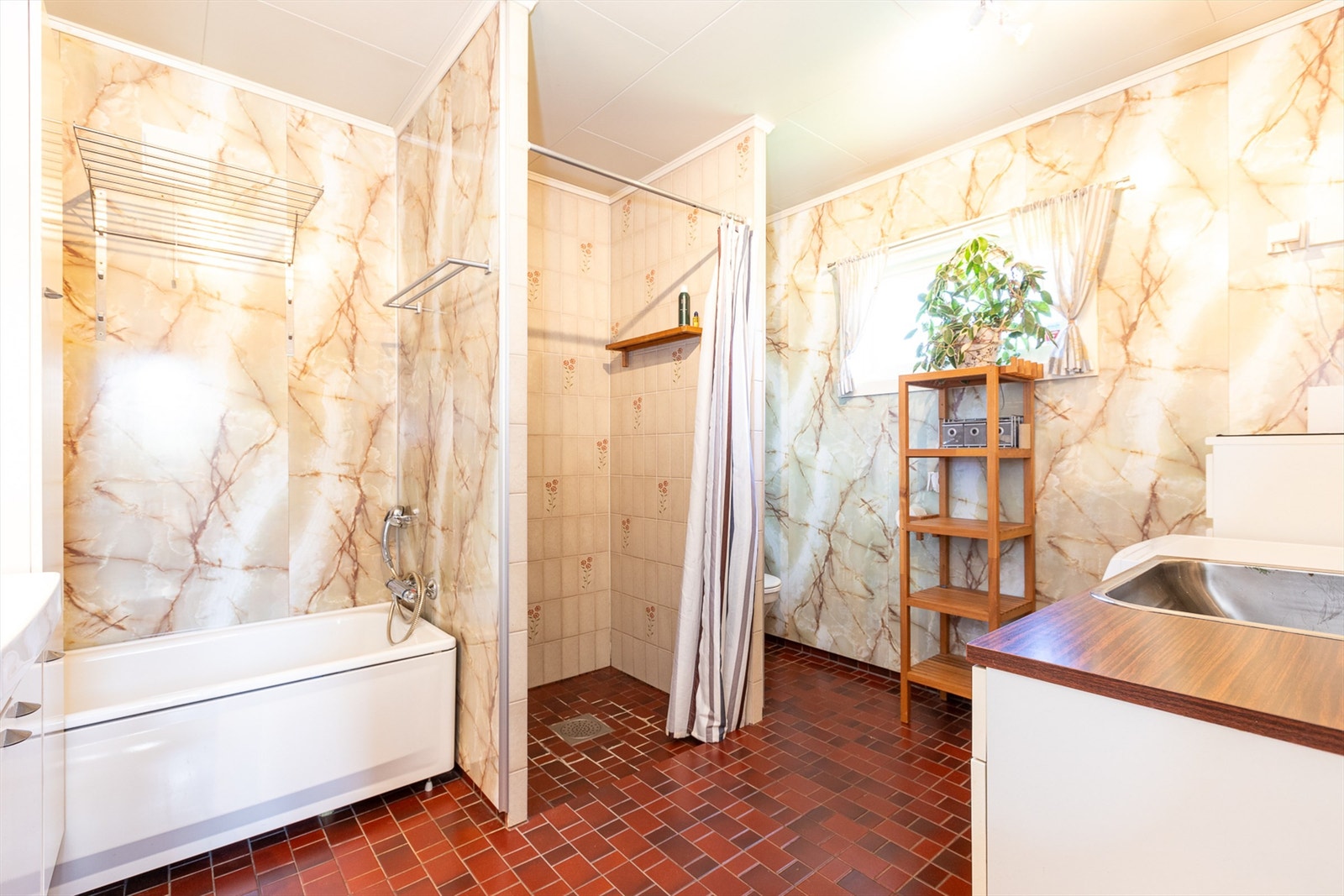 Badet har flislagte gulv med behagelige varmekabler og våtromsplater på veggene Galleribilde