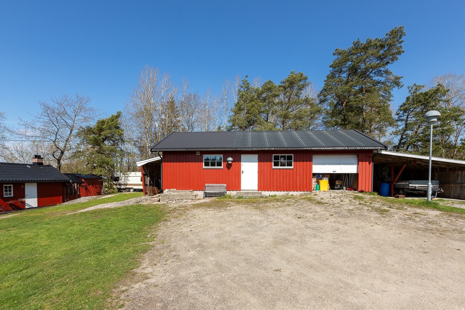 Det isolerte snekkerverkstedet har god plass og er praktisk kombinert med både garasje og carport - en funksjonell løsning som gir ly for bil og utstyr, samtidig som det legger til rette for hobbyprosjekter året rundt. Galleribilde
