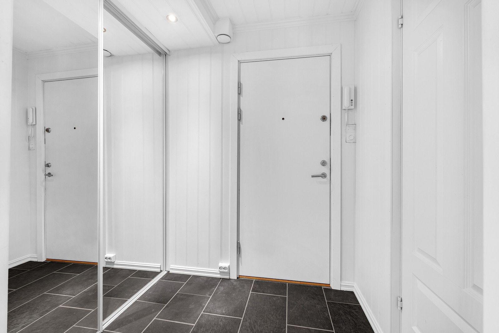 Velkommen til en lys og innbydende entré med fliser på gulv og innebygd skyvedørsgarderobe. Galleribilde