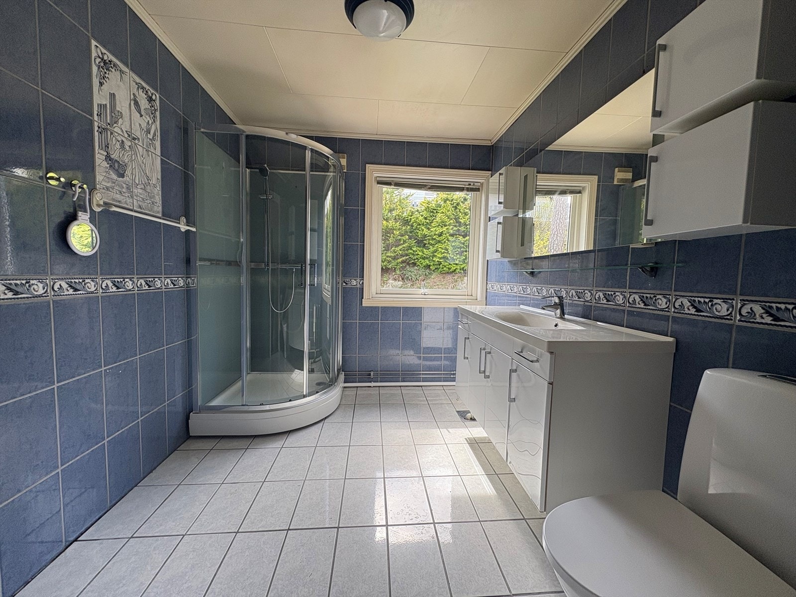 Badet er fliselagt og har varmekabler og utstyrt med dusjkabinett (nytt 2025), wc og servantinnredning med under- og overskap. Galleribilde