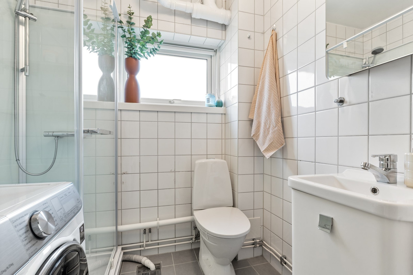 Tidløst og flislagt bad med gulvvarme og opplegg til vaskemaskin. Badet ble rehabilitert i 2001 i regi av borettslaget. Nye gulvfliser med varmekabler fra 2017. Galleribilde