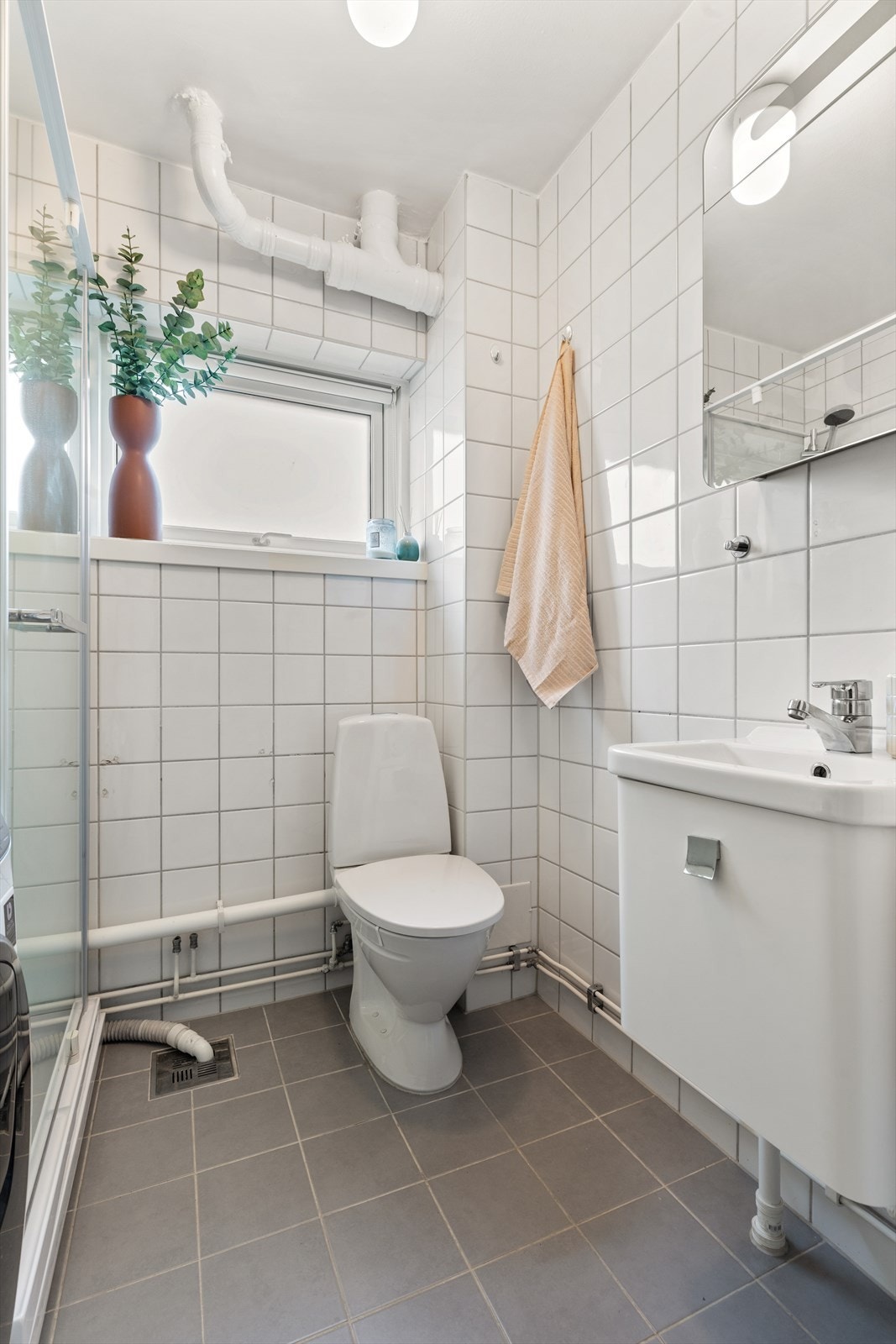 Innredningen består av vegghengt servantskap, vegghengt speilskap over servant, dusjkabinett og toalett. Vaskemaskin (kombi vask og tørk) medfølger. Galleribilde