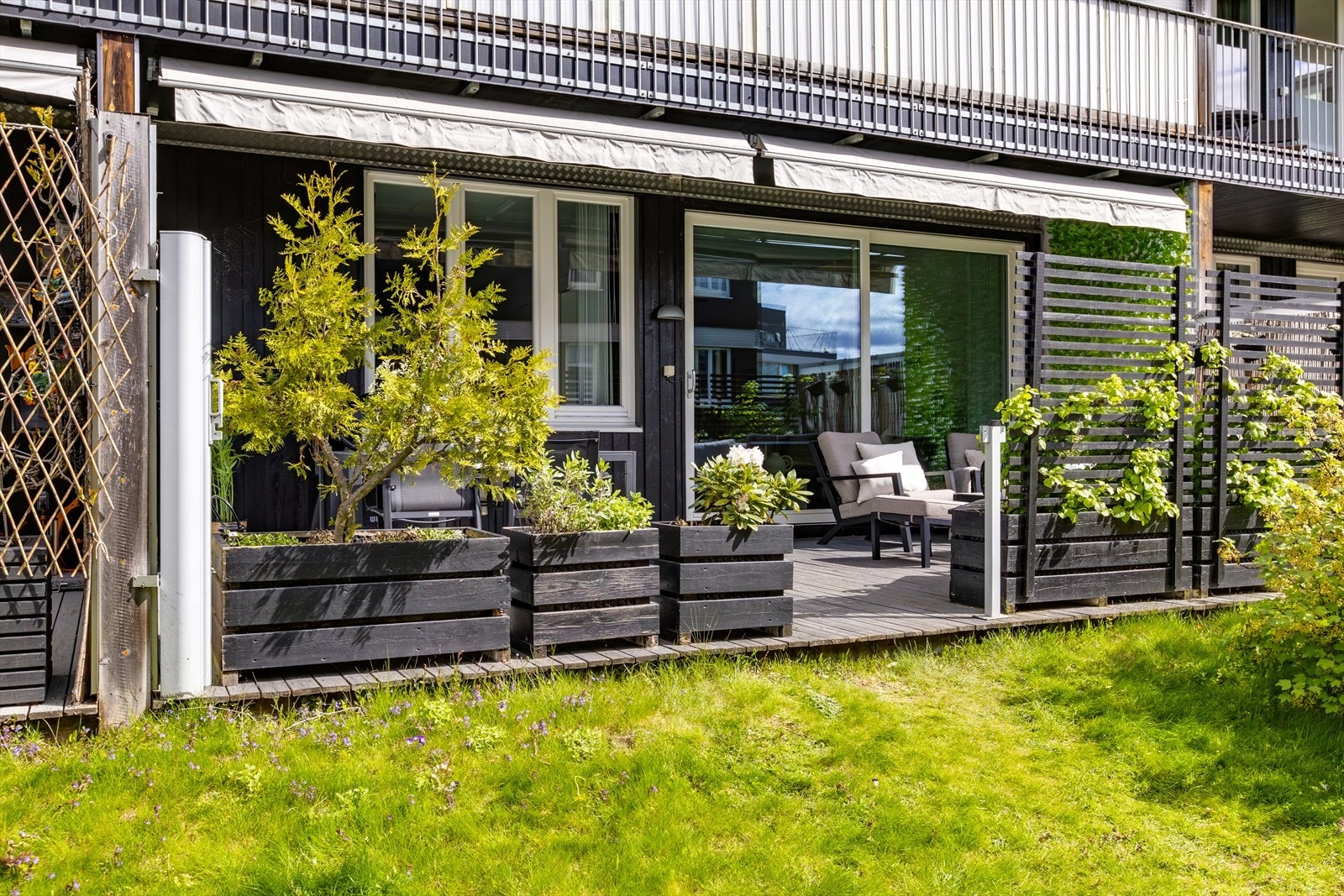 Sommer/vår: "-Vår og sommer er en veldig fin tid her, det blir grønt, dørene i stuen åpnes opp og du får det ekstra rommet på terrassen. Her har du sol fra morgen til kveld, så terrassen har blitt mye brukt til samvær og dyrking."sier selger Galleribilde