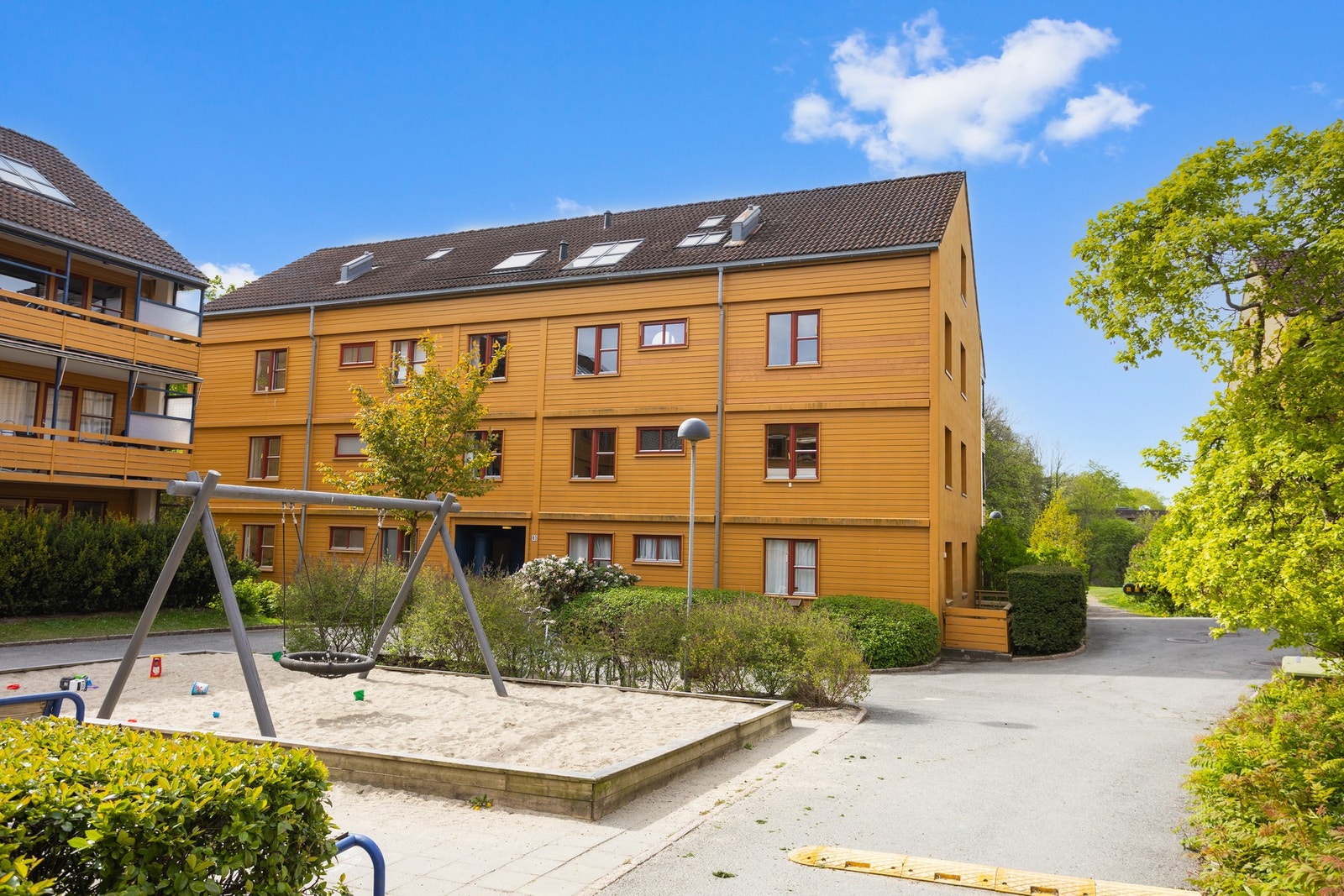 Hyggelig leketun med sittegrupper utenfor blokken. Galleribilde