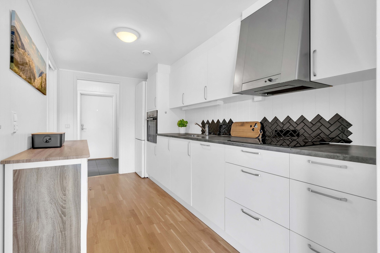 Integrerte hvitevarer som komfyr fra Bosch i høyskap, nedfelt induksjonstopp fra Bosch med komfyrvakt og oppvaskmaskin. Galleribilde