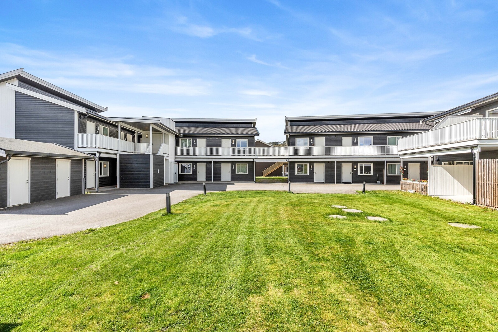 Fellesarealer opparbeidet med asfalterte internveier, plenareal og diverse beplantninger. Galleribilde