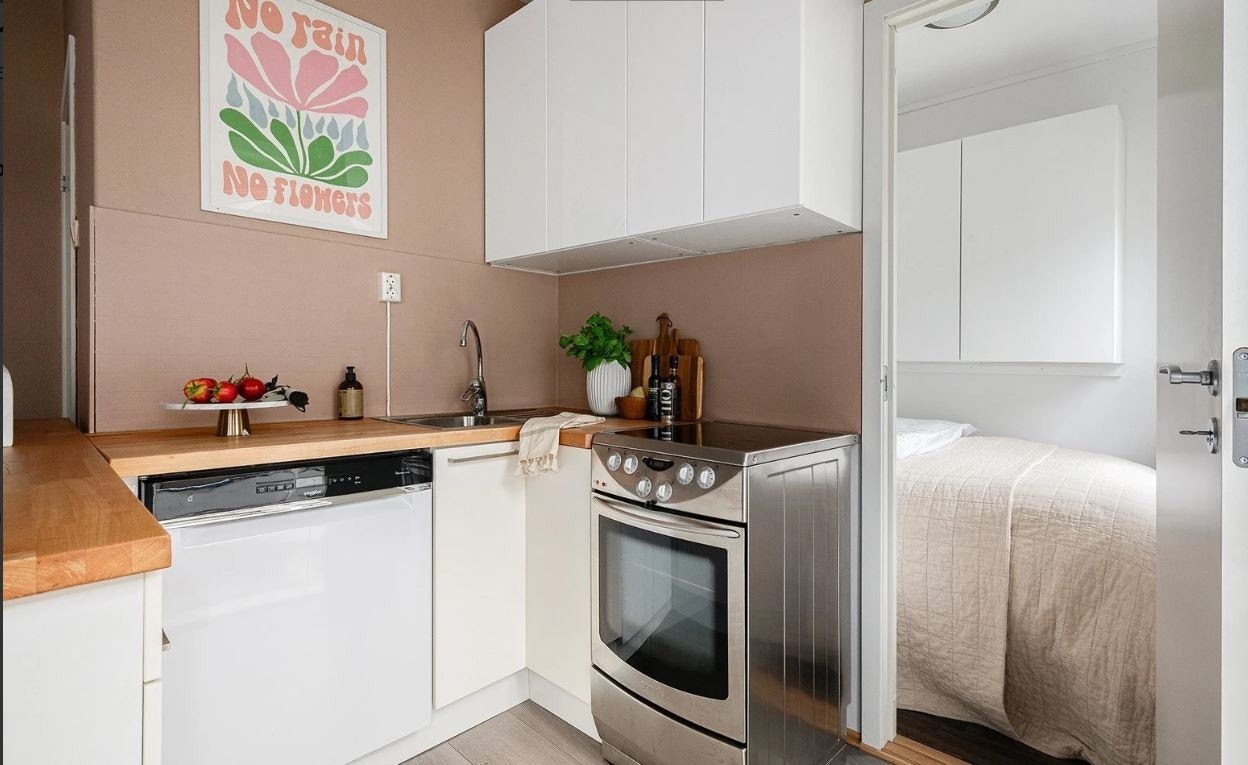 Kjøkken med hvitevarer som komfyr, oppvaskmaskin 60 cm bred og kjøleskap med liten fryser. Galleribilde