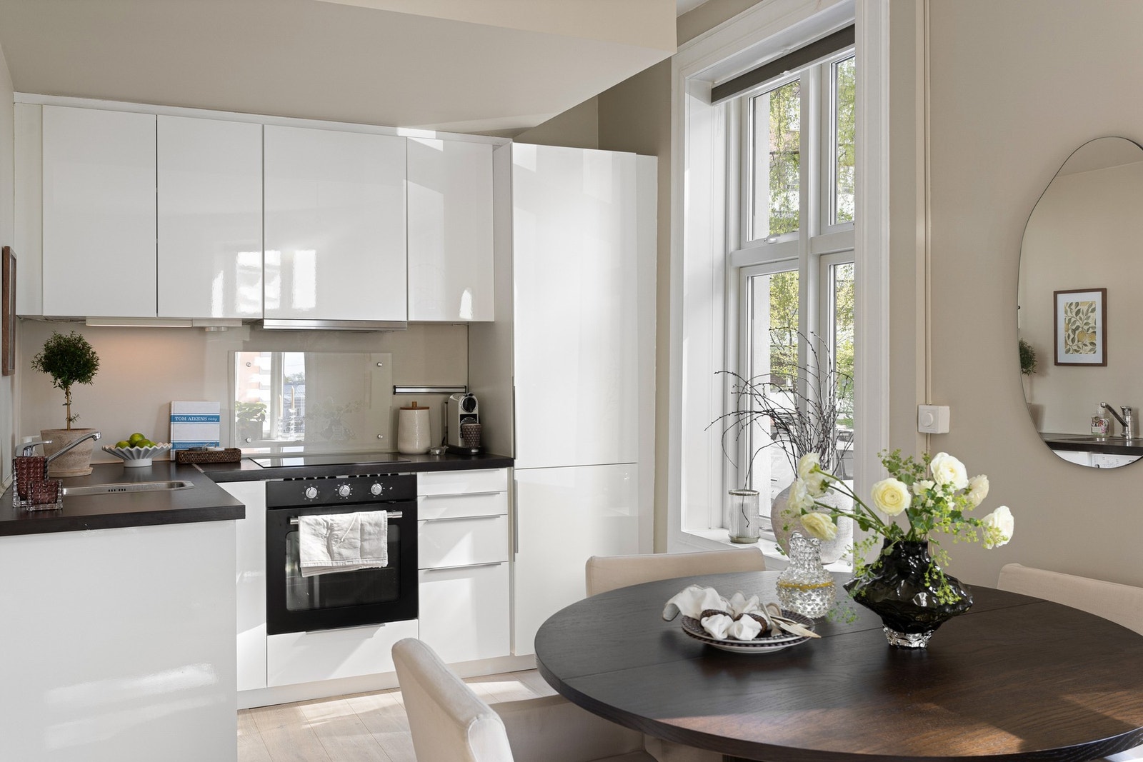 Innredningen har slette høyglansfronter og laminat benkeplate med underlimt oppvaskkum og nedfelt induksjon koketopp. Galleribilde