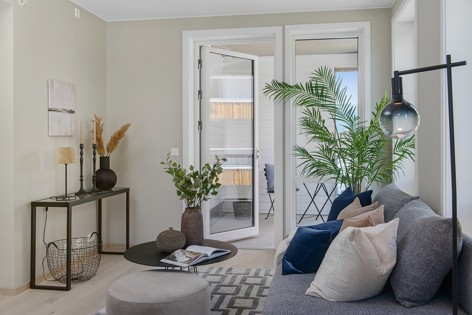 Lys stue med store vindusflater og utgang til balkong Galleribilde