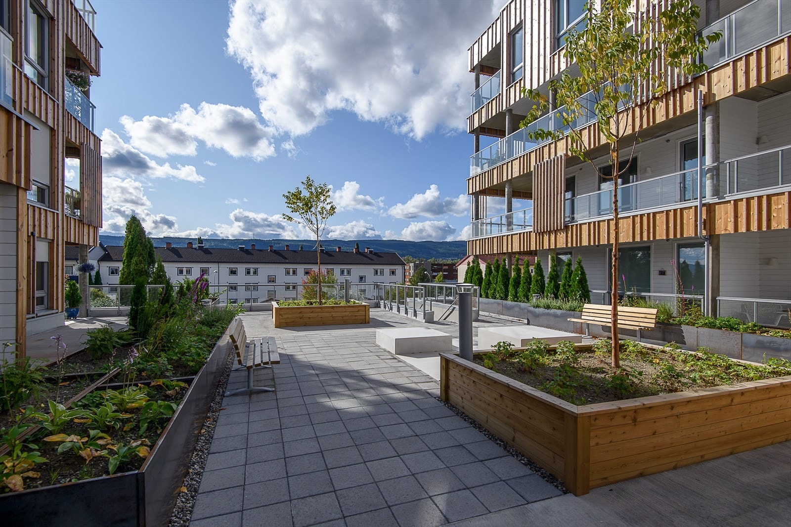 Mellom de to byggene er det etablert et bytorg som kan benyttes av beboerne. Bytorget er utformet med sitteplasser, beplantning og har enkel adkomst både fra øst og vest. Galleribilde