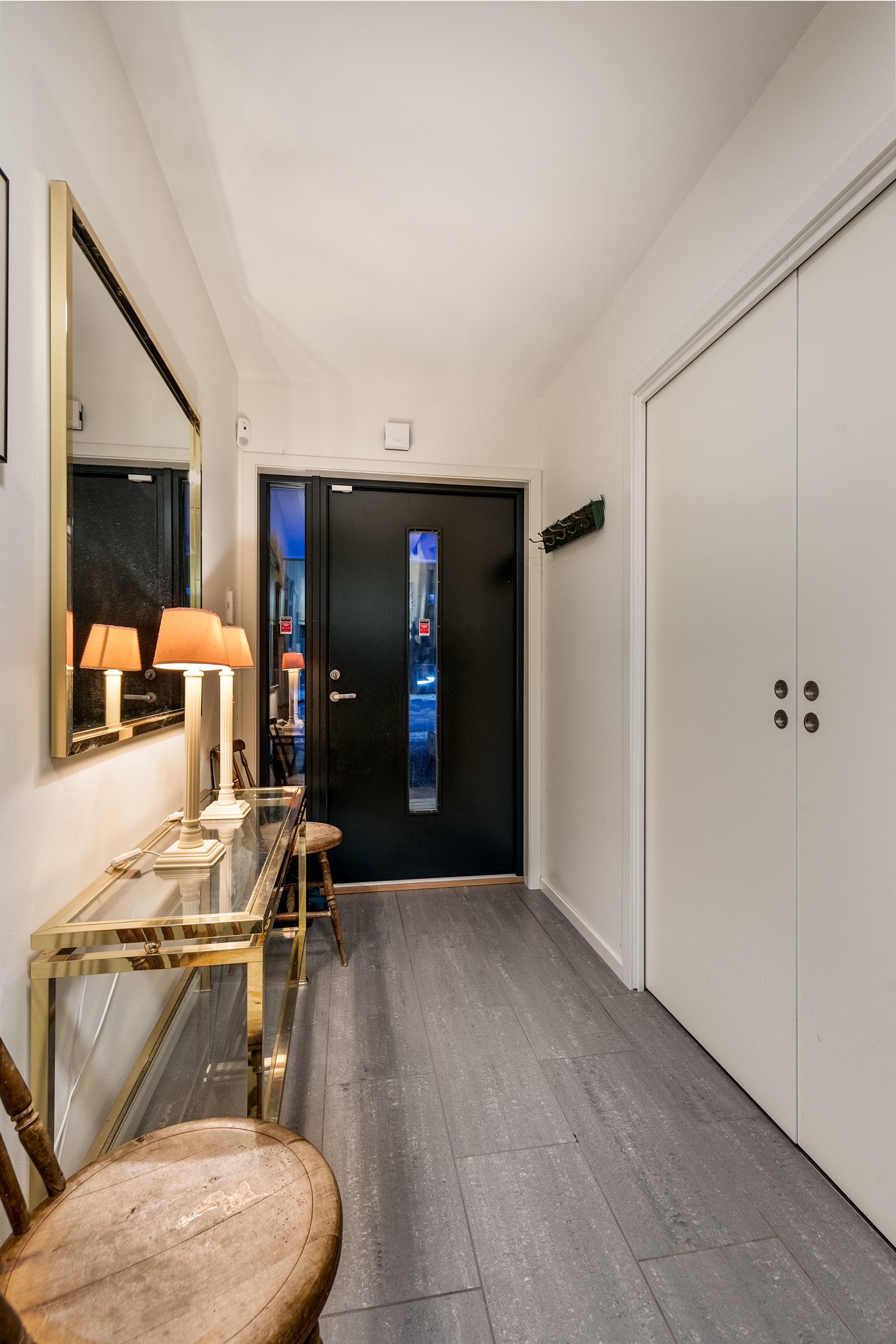 Innbydende entre med fliser på gulv og malte gipsvegger. Det er skyvedørsgarderobe med god plass til oppbevaring av klær og sko. Åpen entre som gir et godt førsteinntrykk av boligen. Varme i gulv. Galleribilde