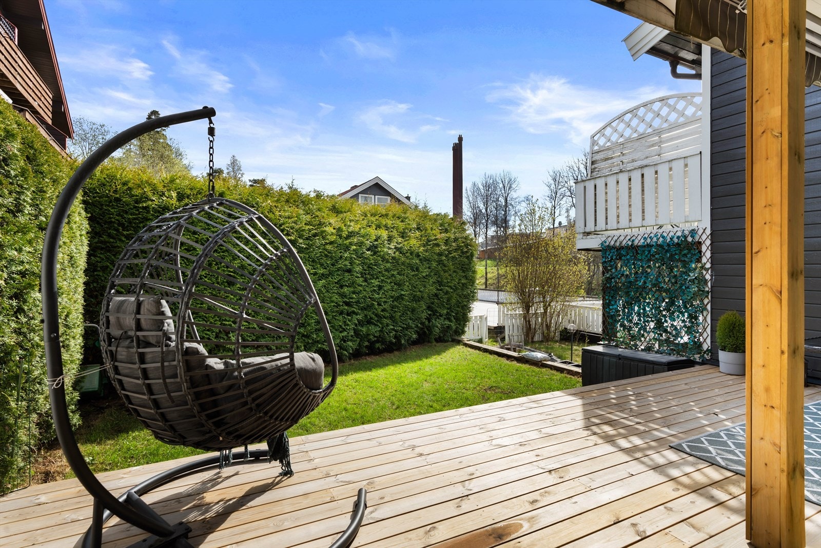 Utenfor terrassen er det utgang til sameiets fellesareal, med plen, beplantning og hekk. Galleribilde