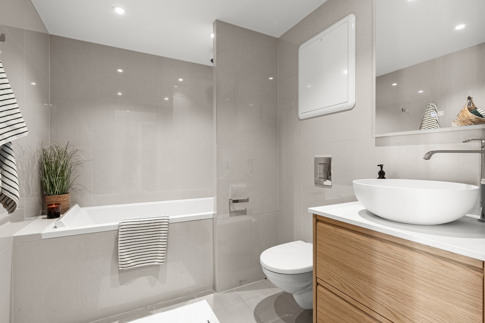 Flislagt bad med moderniseringer fra 2018 og 2024. Downlights i himlingen gir en lun stemning, og innredningen har glatte fronter og praktisk servant. Galleribilde