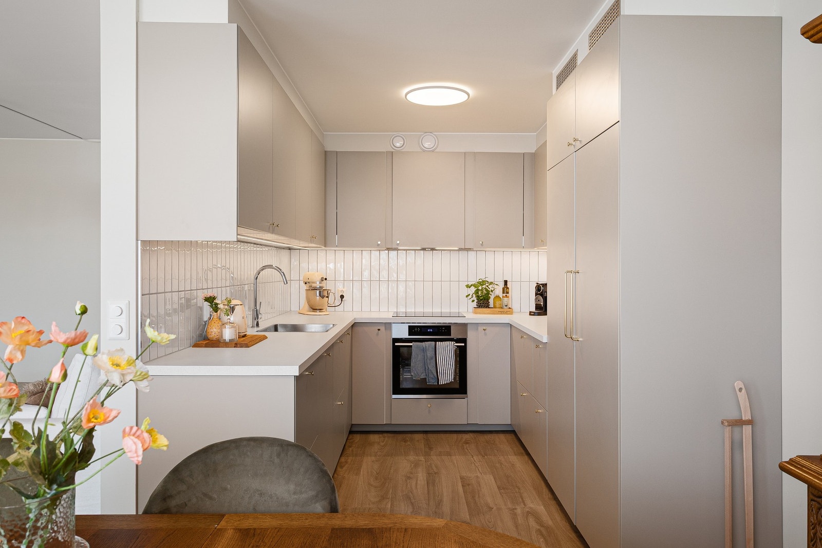 Moderne kjøkken med integrert fryseskap, kjøleskap, oppvaskmaskin, stekeovn og platetopp. Galleribilde