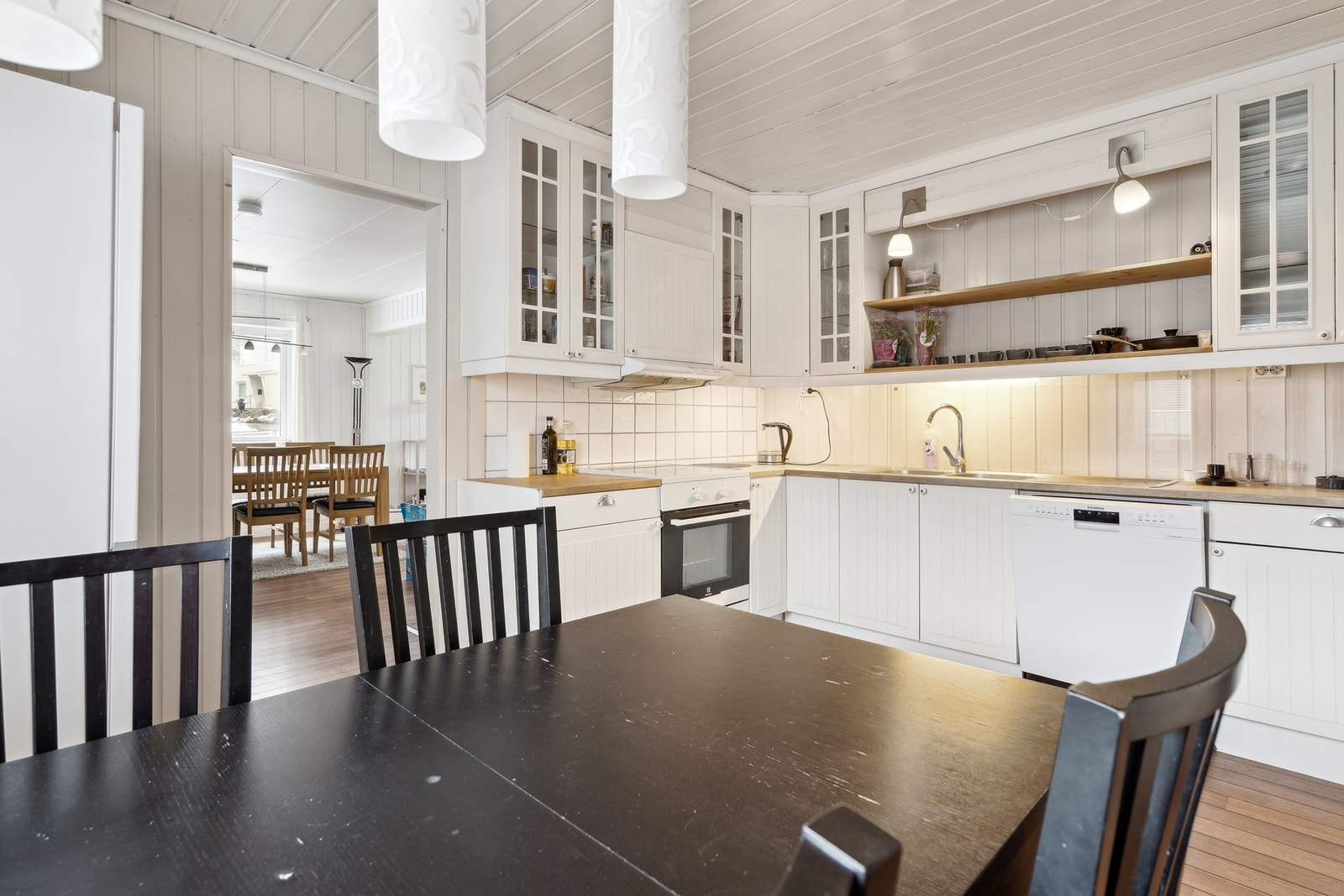 Kjøkken med flott hvit innredning med god skap og benkeplass Galleribilde