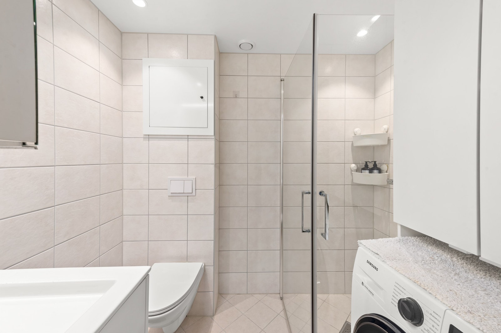 Badet er pent flislagt på gulv og vegger med varme i gulvet fra 2020. Baderomsinnredningen består av vegghengt servantinnredning med servant. Over servanten er det speil. Galleribilde