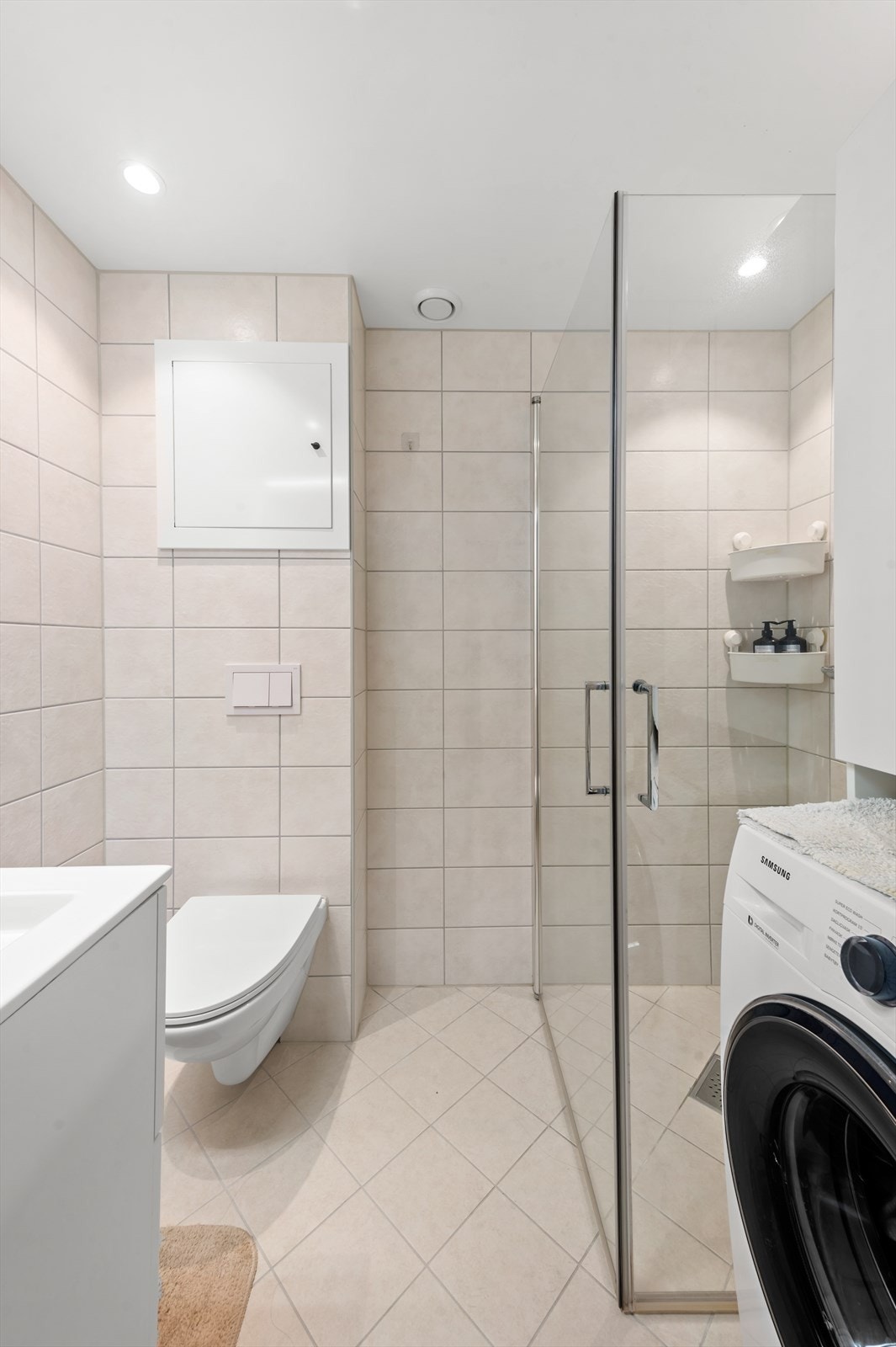 Videre har badet dusjhjørne med svingbare glassdører og vegghengt toalett. Det er opplegg for vaskemaskin. Galleribilde