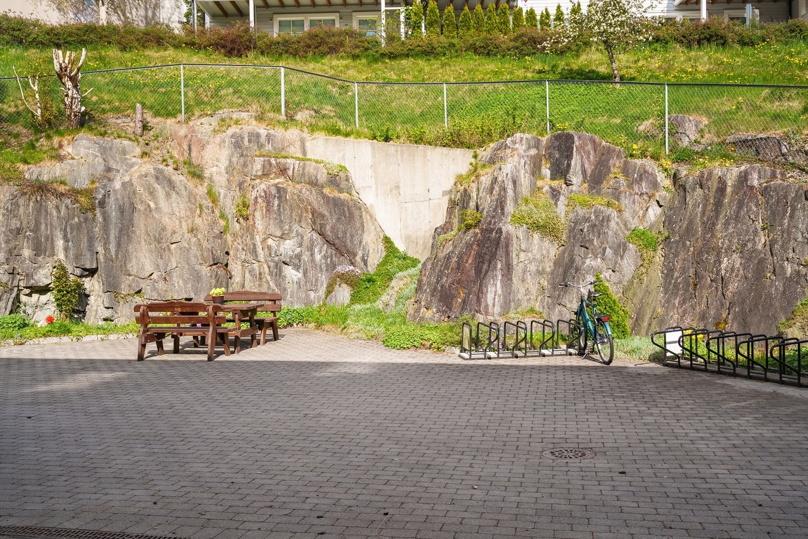 Pent opparbeidet bakområde med belegningsstein, hyggelig sittegruppe og sykkelstativ Galleribilde