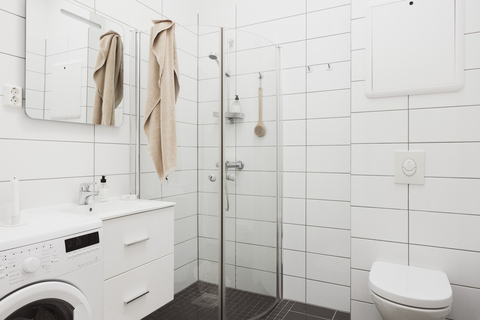 Badet er helfliset med slett malt himling. Her er det varmekabler i gulv og opplegg for vaskemaskin. Galleribilde