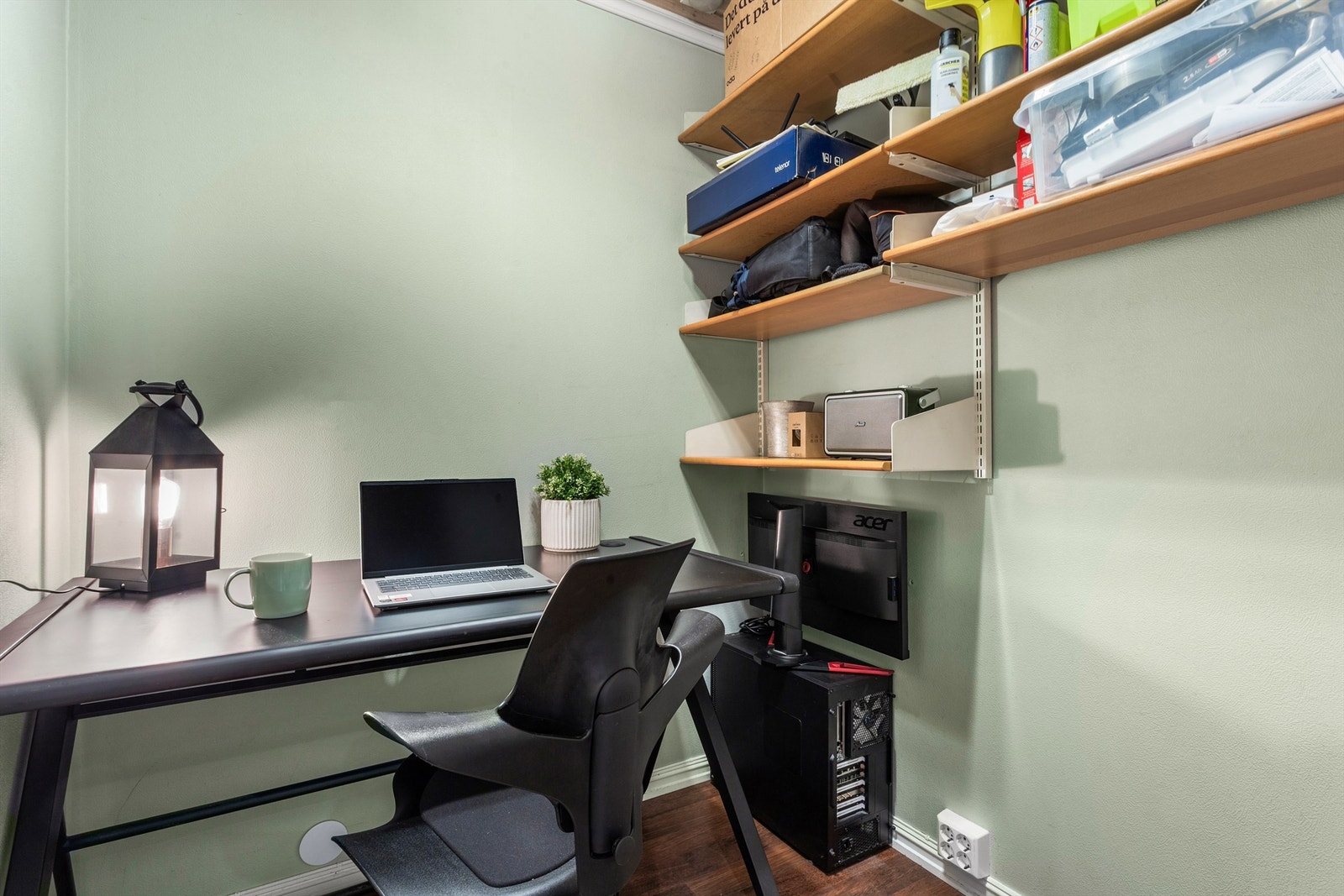 innvendig bod med veggmonterte hyller, benyttes av selger som hjemmekontor Galleribilde