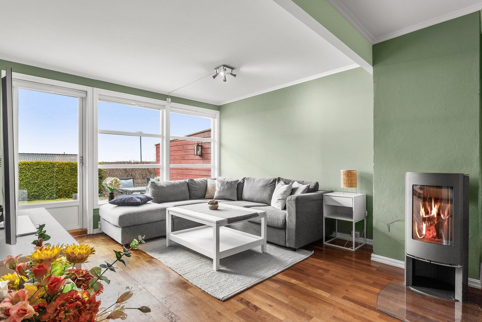 Stuen har store vindusflater og hyggelig vedovn for lun og god varme i vinterhalvåret Galleribilde