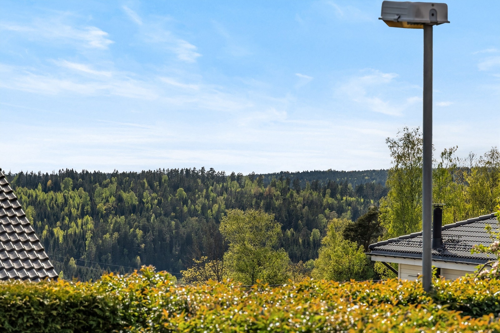 Uteplassen ligger hevet i terrenget med fin utsikt fra platting/hage Galleribilde