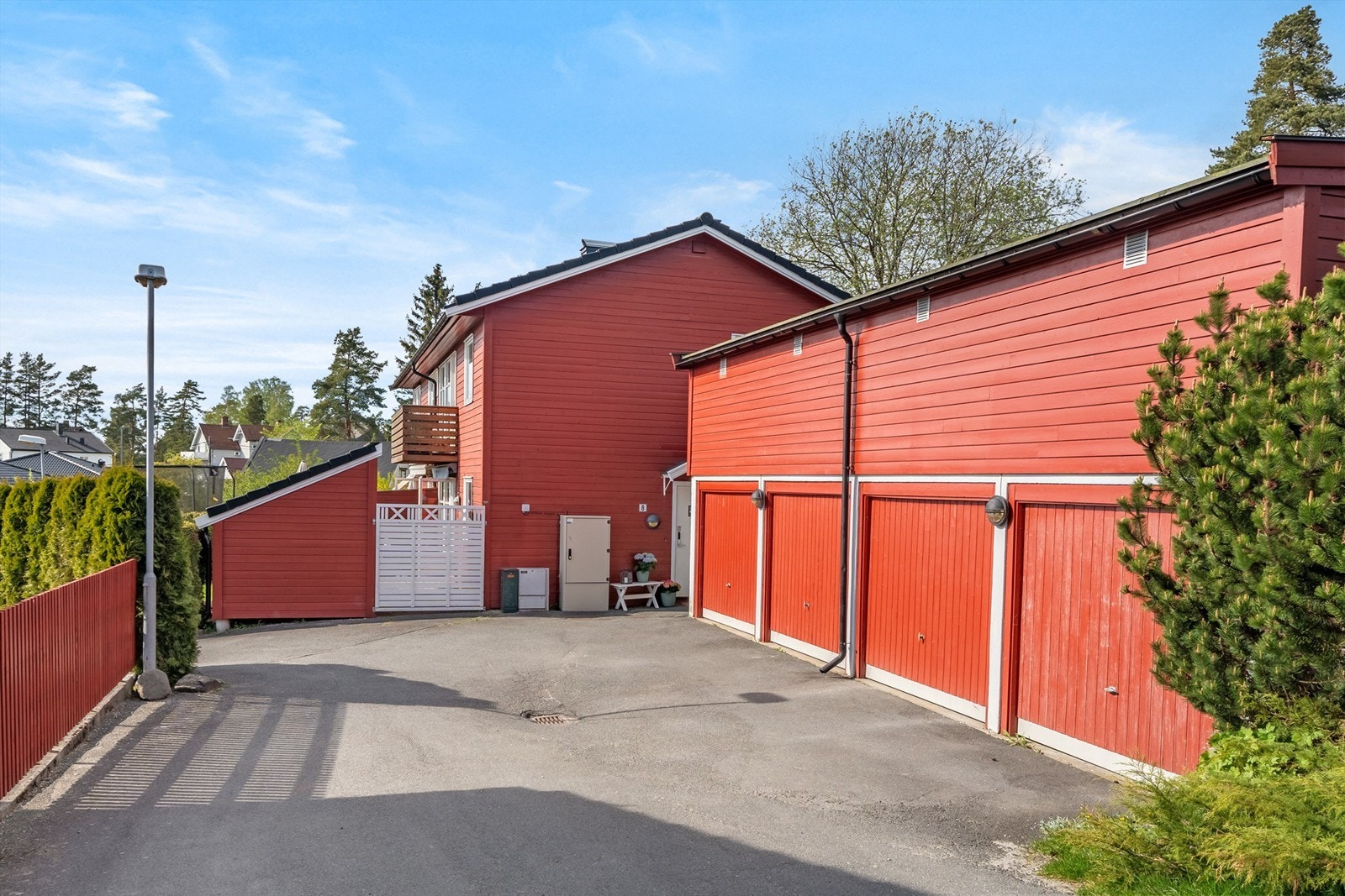 Leiligheten har overbygget inngang i gavlveggen på bygget, kort vei til garasjen Galleribilde