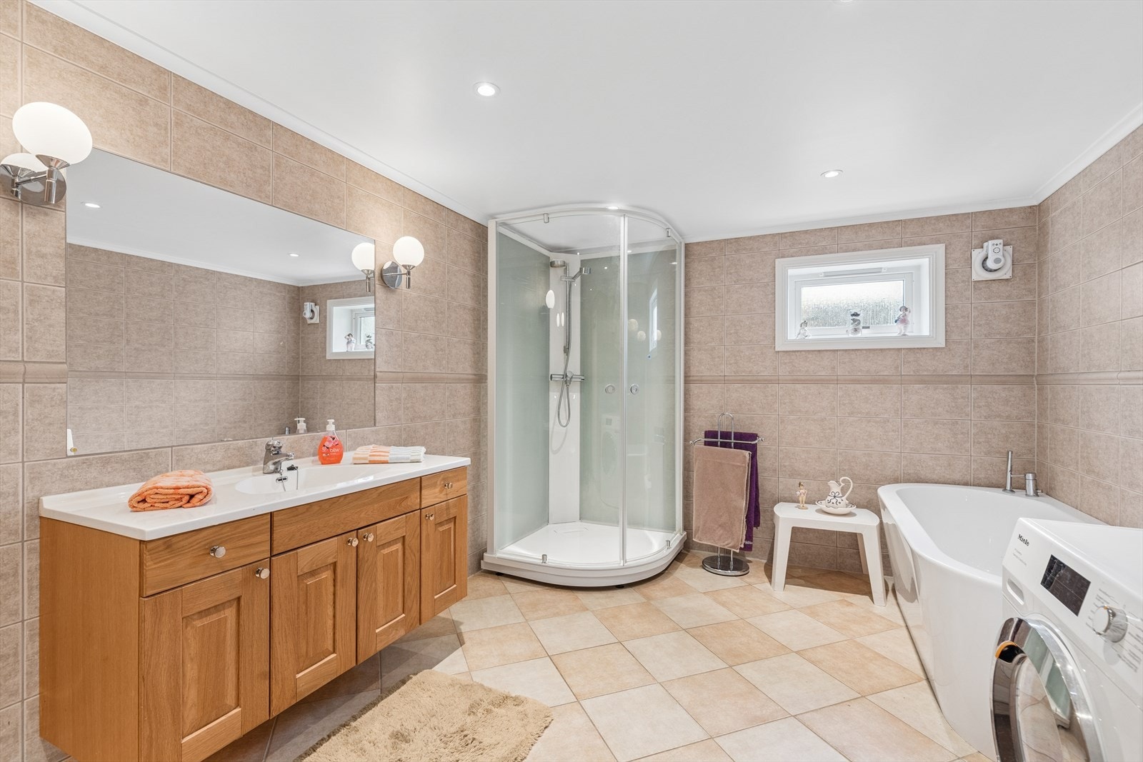 Det er flislagt bad/vaskerom med elektriske varmekabler fra 2004. Innredet med: dusjkabinett, vegghengt toalett, servantinnredning, frittstående badekar, innmurt speil på vegg over servant. Det er også opplegg for vaskemaskin. Galleribilde