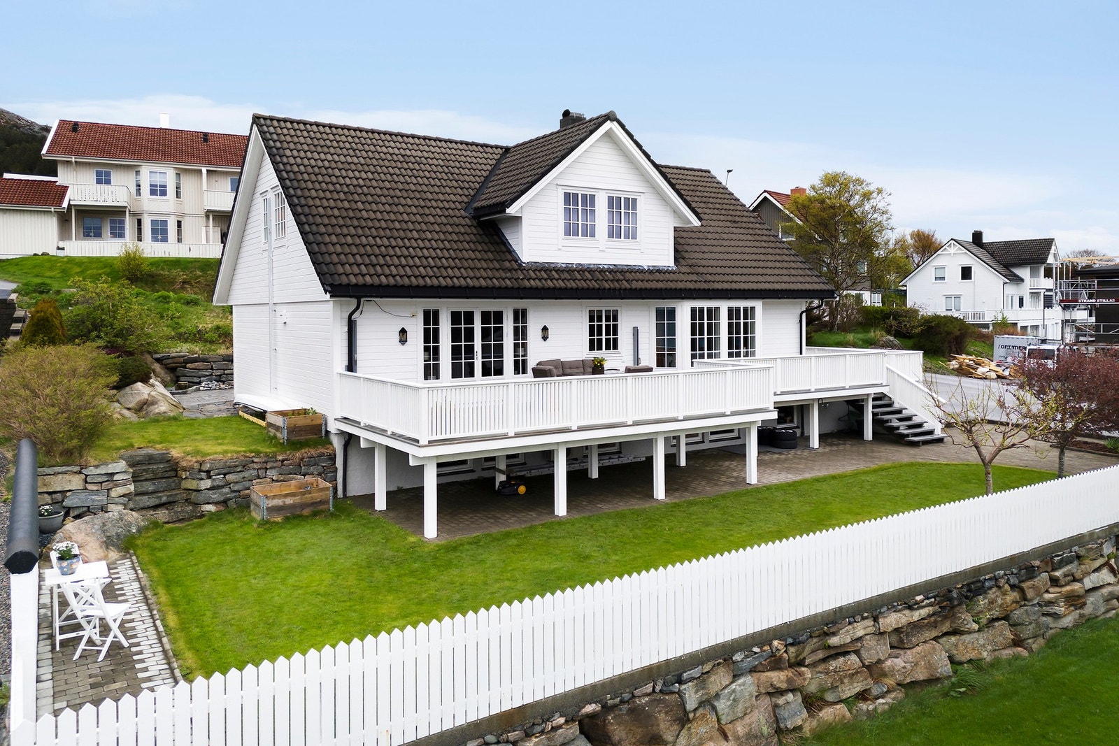 Fasade mot syd. Taket har for øvrig Zanda takstein, legg merke til gavlstein over vindskier, trapp ned fra terrasse og den flotte natursteinsmuren Galleribilde