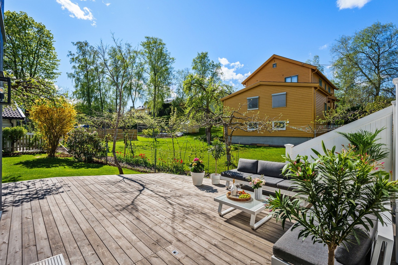Boligen er omkranset av en stor solrik hage med flere uteplasser i barnevennlige omgivelser. Galleribilde