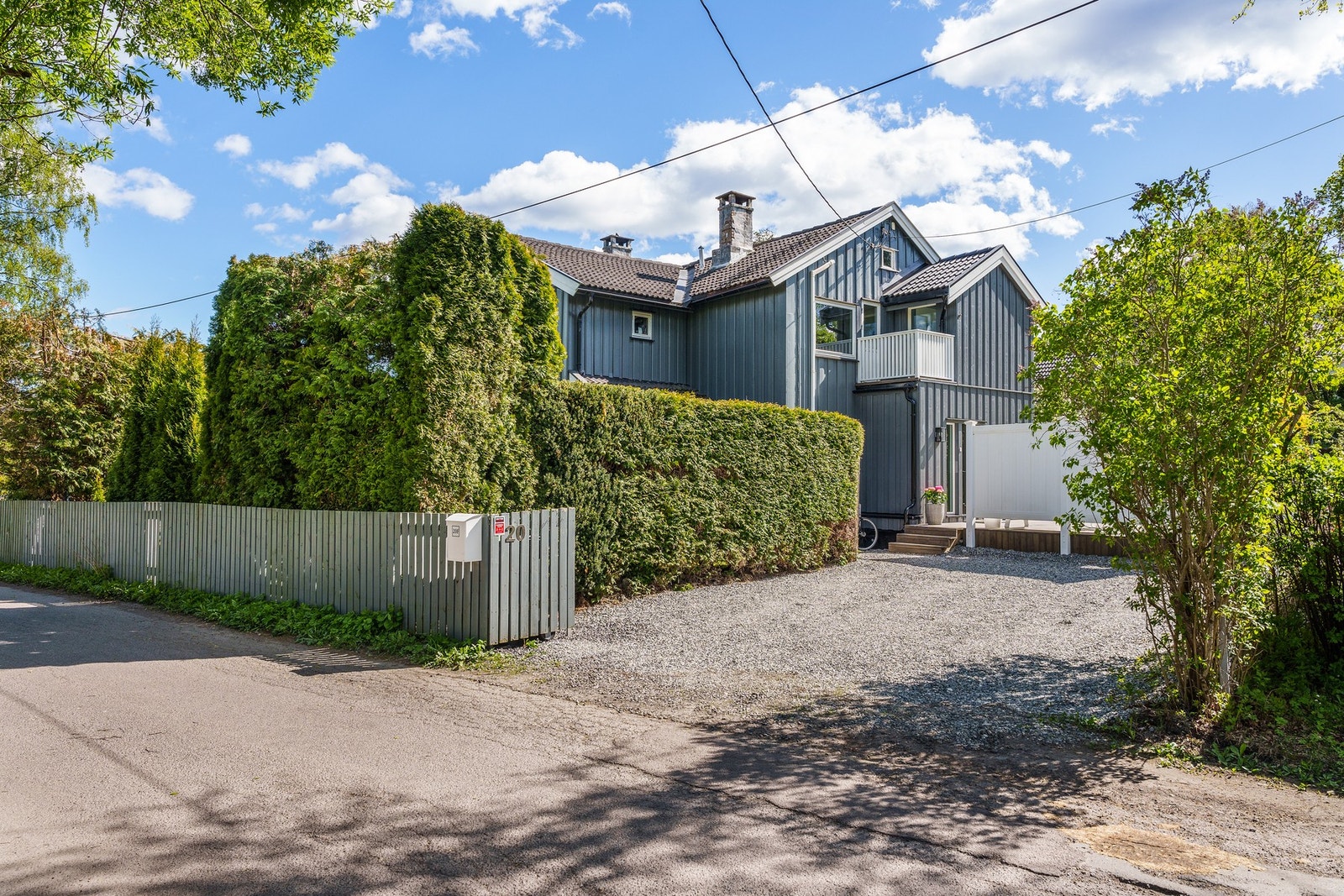 Innkjøring til gårdsplass med parkeringsplasser på terreng. Galleribilde