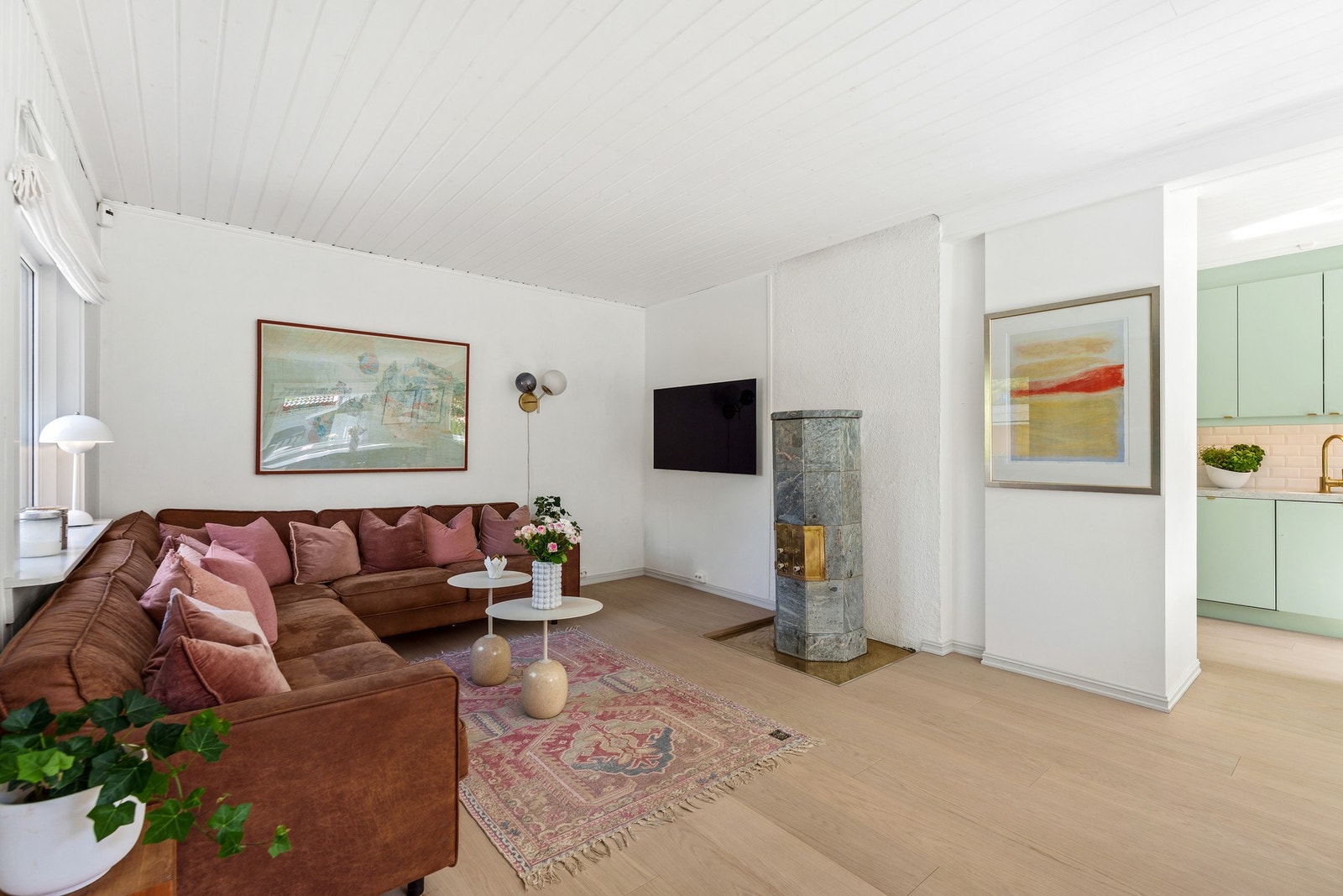 Lyse enstavs eikegulv i oppholdsrom og vakker peisovn i kleberstein. Galleribilde