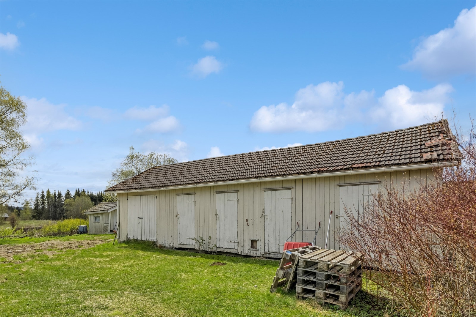 Eldre uthus med liten garasje og 4 romslige boder. Bygget har noe etterslep på vedlikehold Galleribilde