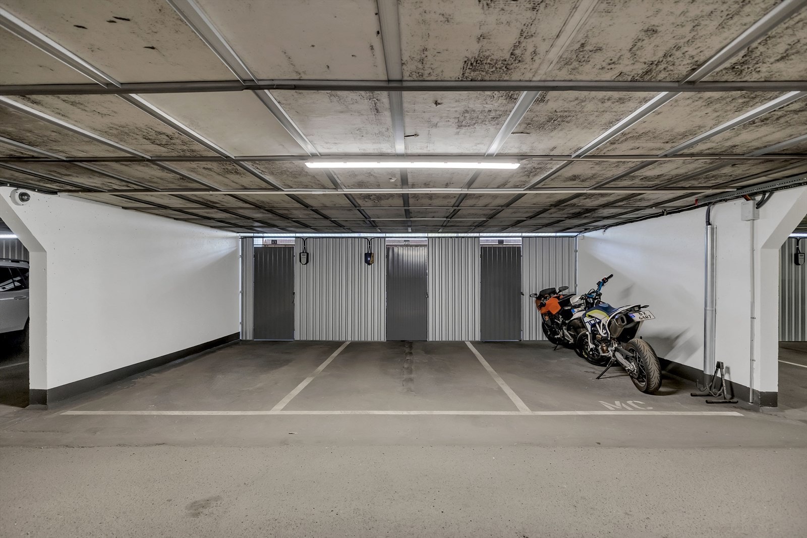 Leiligheten har p-plass i felles garasjeanlegg med adkomst gjennom kjøreport. Det er montert elbillader på plassen. Galleribilde