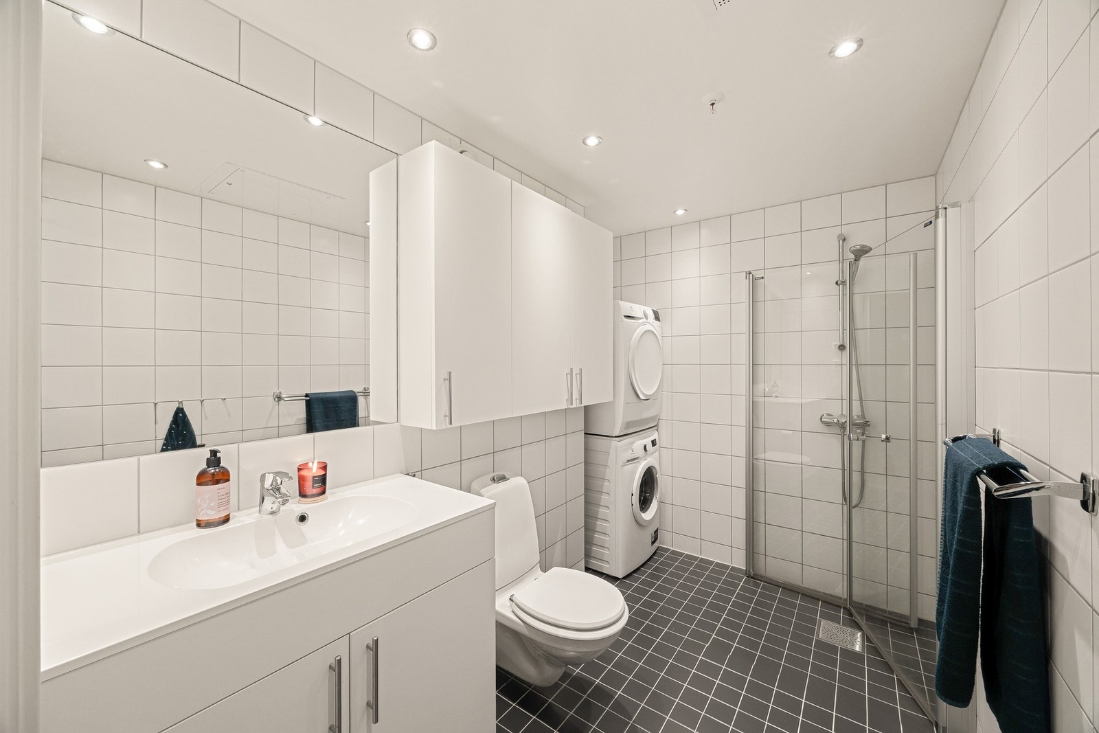 Stort bad fra 2018 med opplegg for vaskemaskin, tørketrommel, innfellbare dusjdører og moderne innredning. Galleribilde