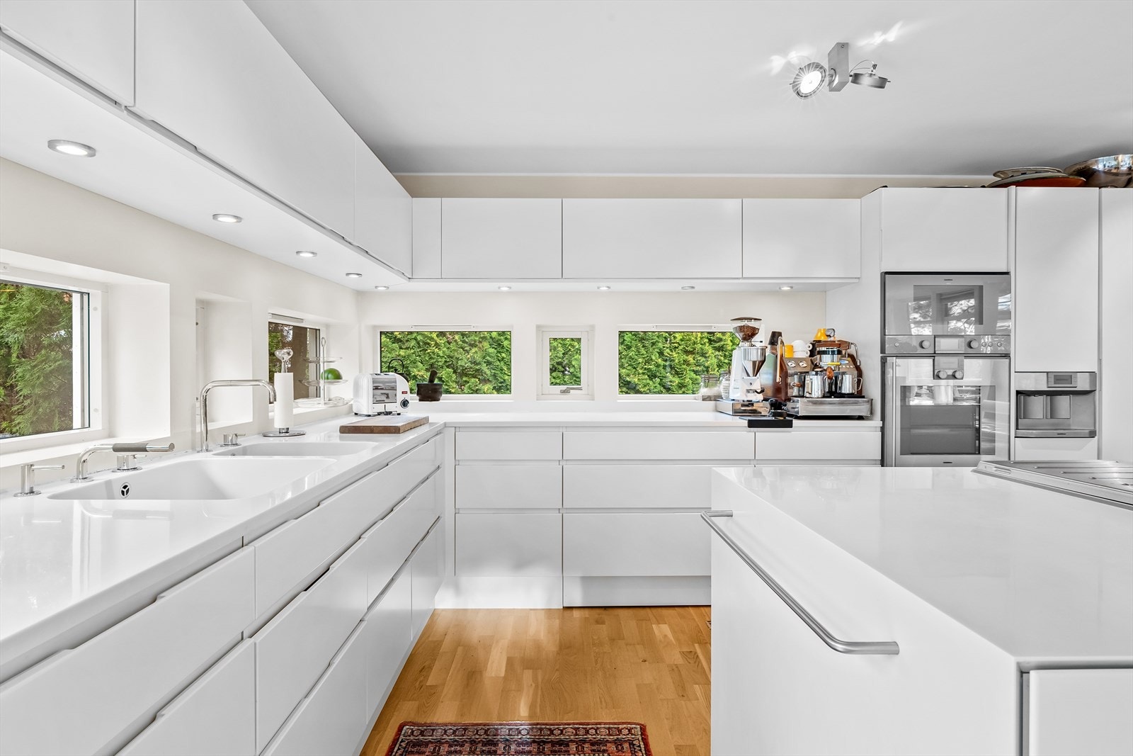 Kjøkkenet har integrerte håndtak og lys under overskap Galleribilde