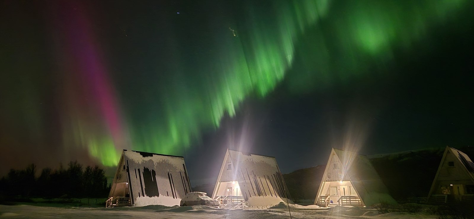 Flott nordlys over hyttene på vinterstid. Galleribilde