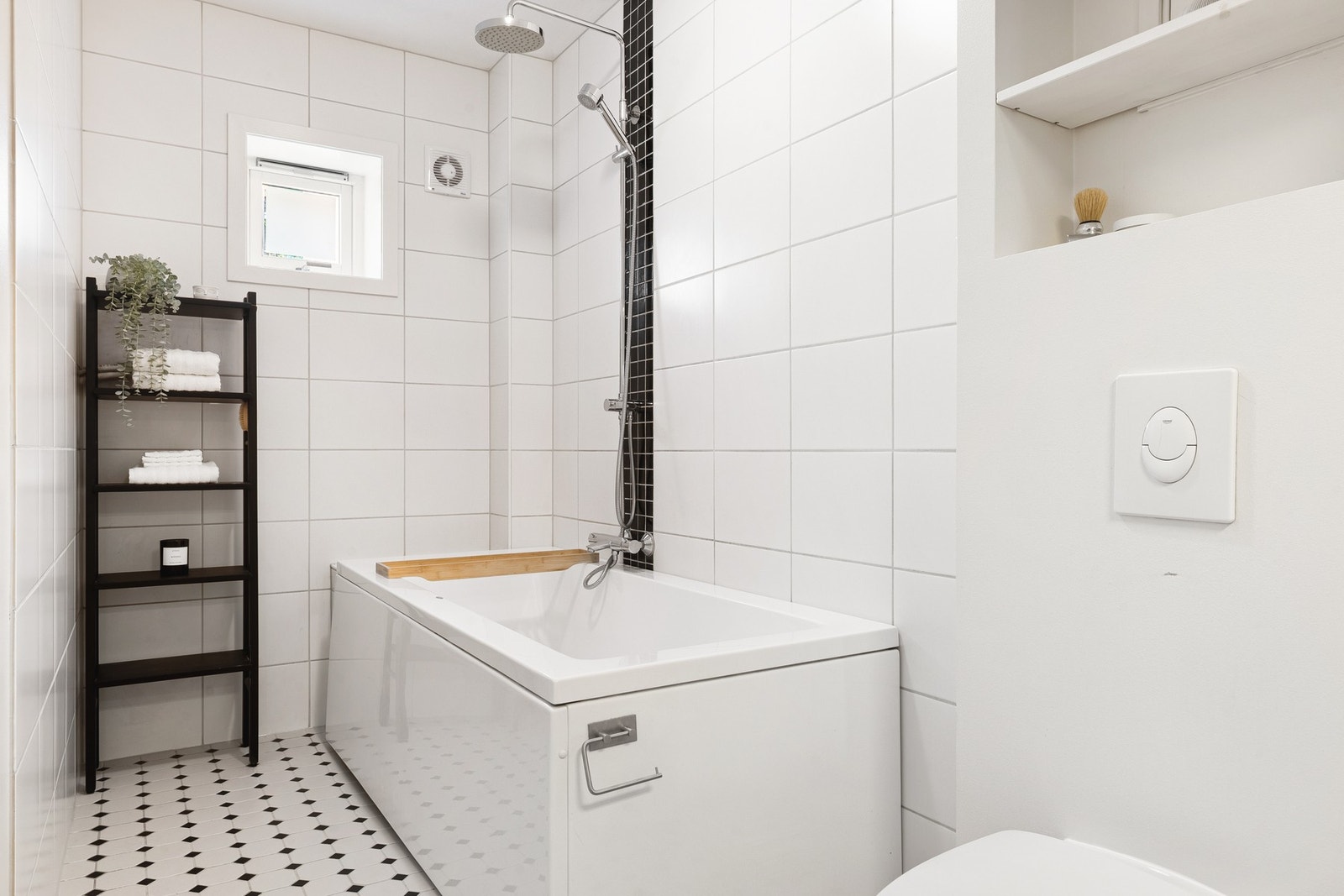 Badet er utstyrt med badekar, veggmontert toalett og heldekkende servant, som gir god plass og praktiske løsninger. Galleribilde