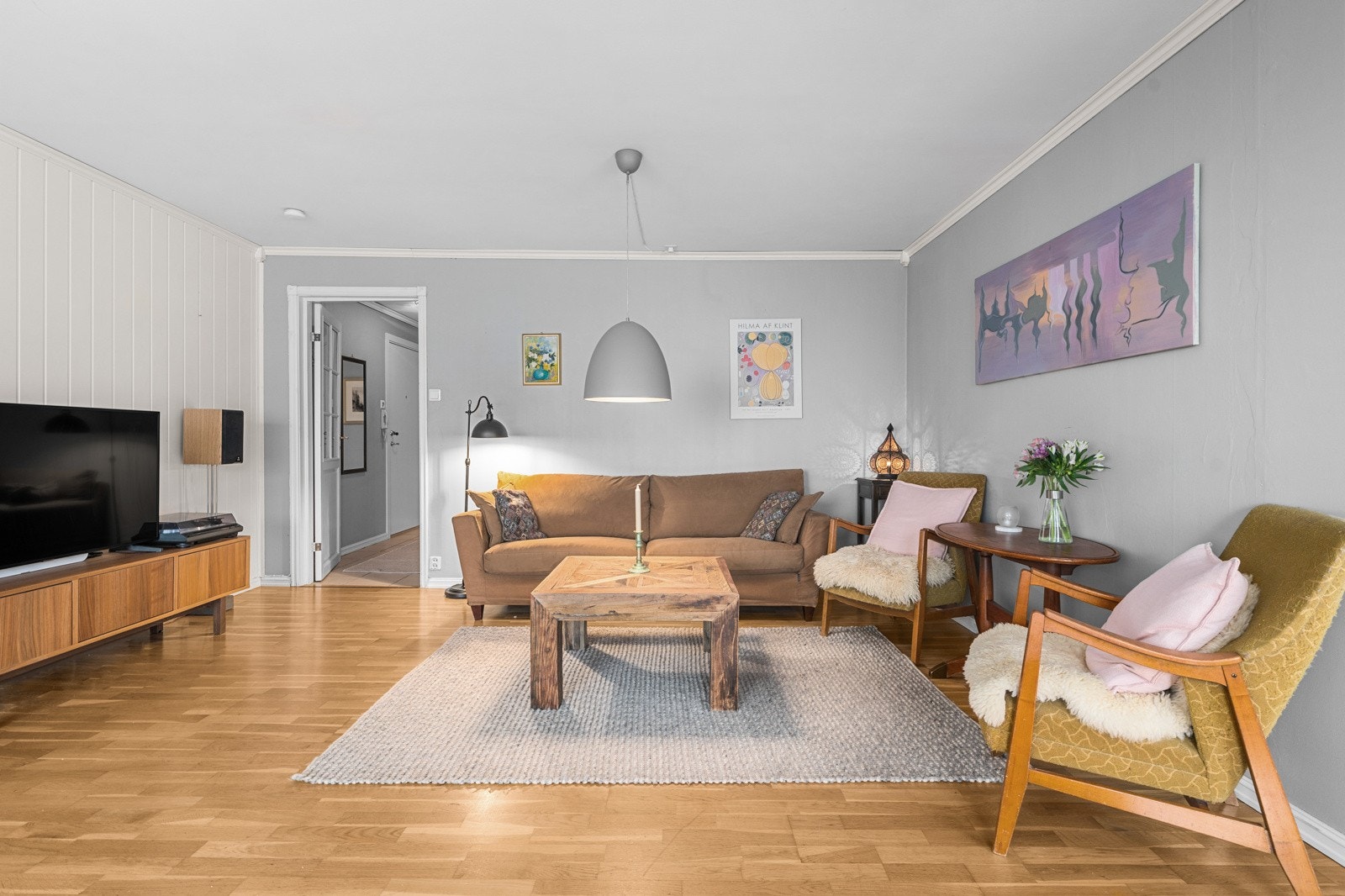 Boligens hjerterom er en romslig tiltalende stue med delvis åpen løsning til kjøkken. Galleribilde