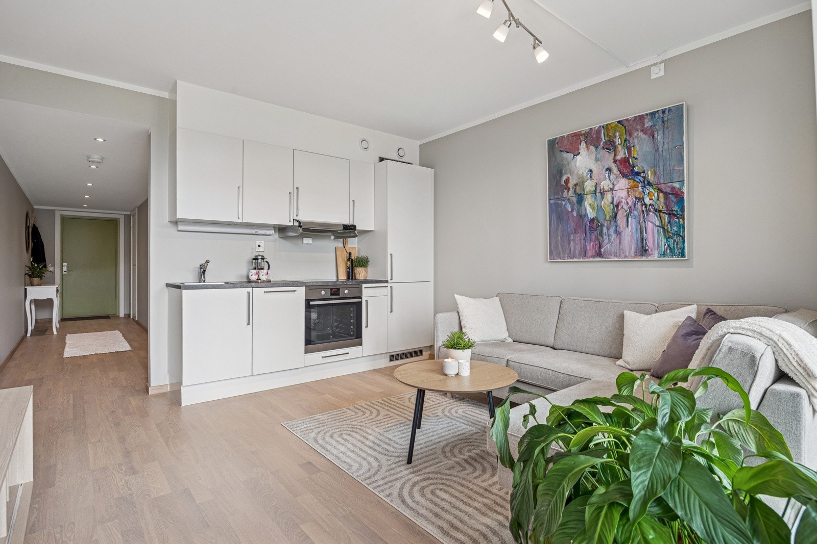 Entréen glir videre over i stue- og kjøkkendel, som totalt utgjør et areal på 14,4 kvm. Integrethe hvitevarer hvor oppvaskmaskin er ny i 2025. Galleribilde