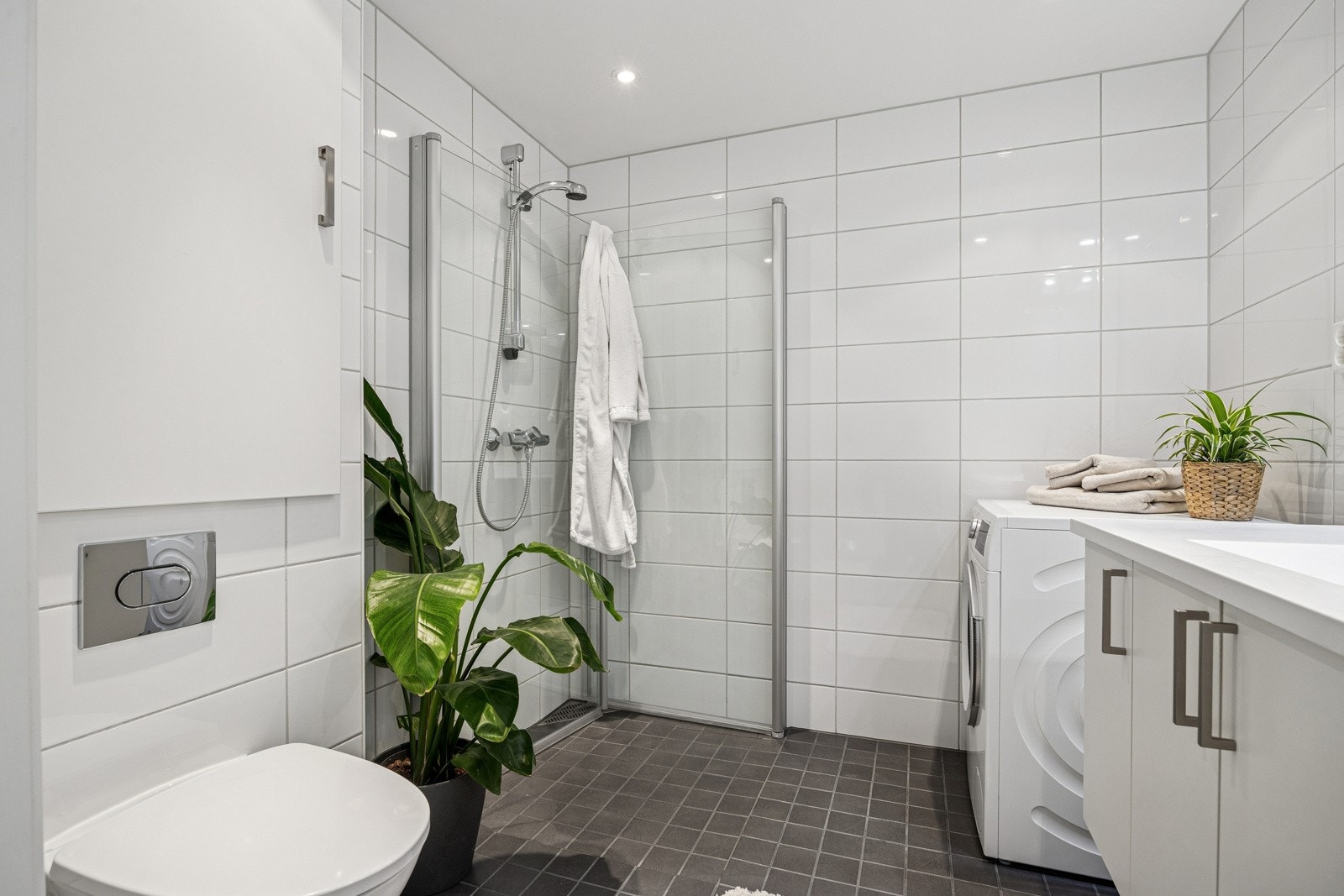 Innredningen består av nedfelt servant, skap til oppbevaring av baderomsartikler, dusjnisje og opplegg for vaskemaskin. God belysning fra downlights i himling og lys over speil. Galleribilde