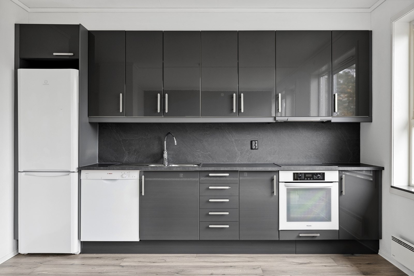 Kjøkkenet har integrerte hvitevarer som medfølger; platetopp og stekeovn, samt frittstående oppvaskmaskin og kjøleskap. Galleribilde