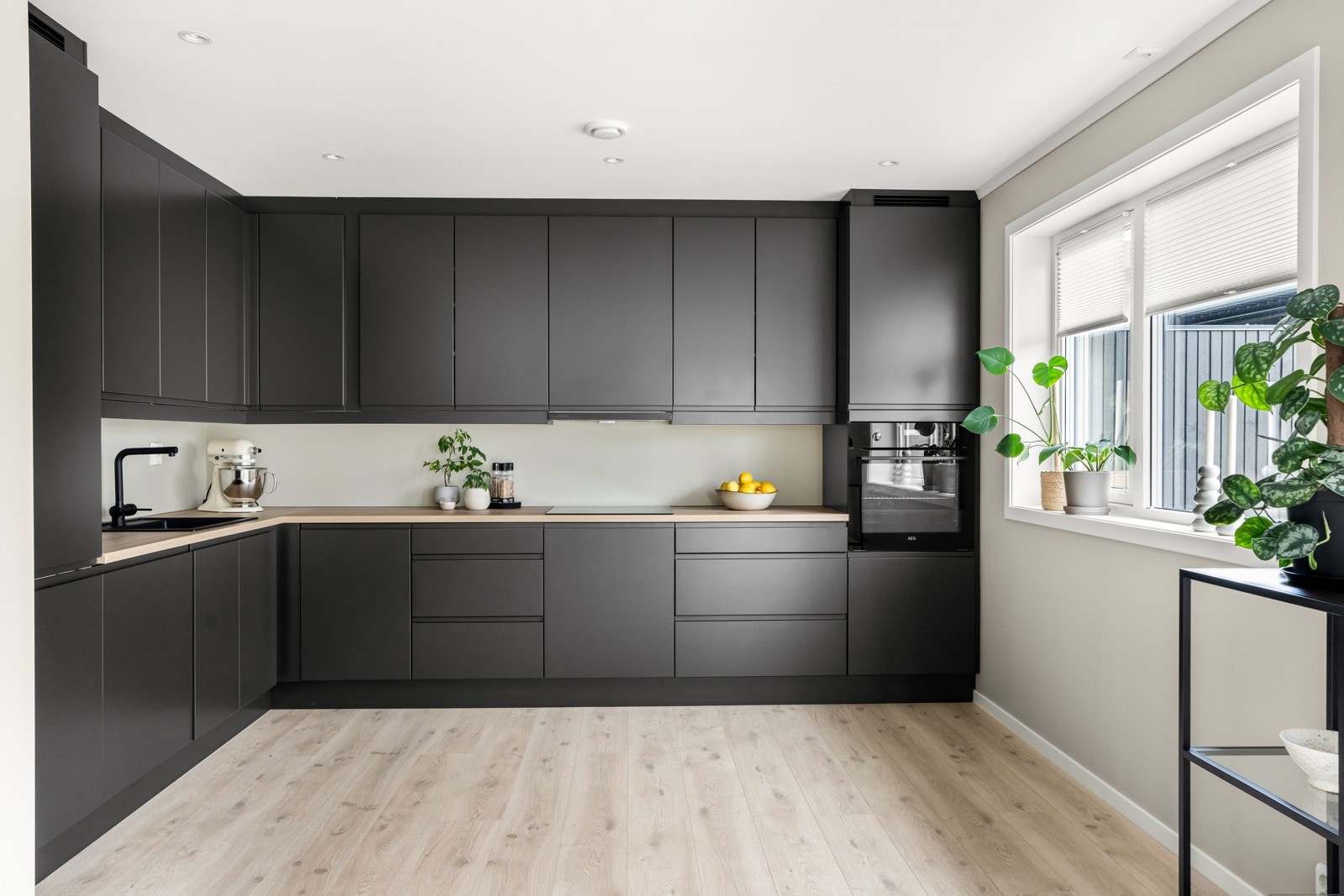 Kjøkkenet har sorte fronter og benkeplate i laminat Galleribilde