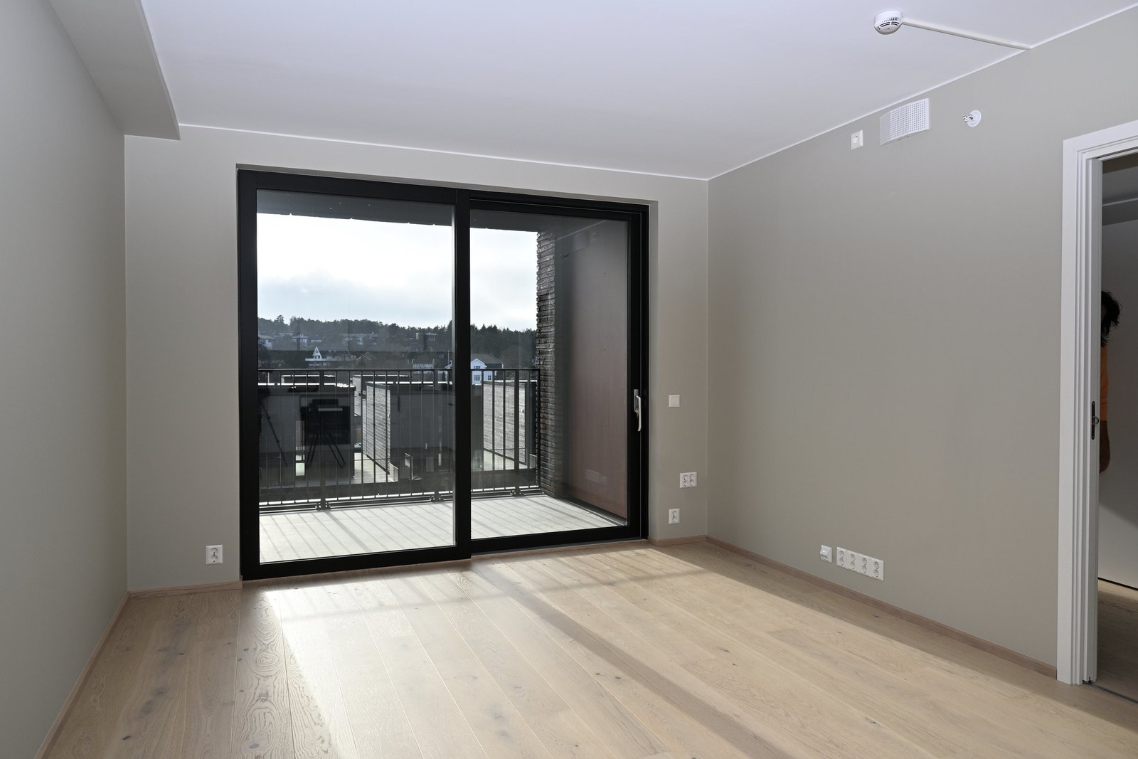 Stua har store vindusflater og skyvedører til balkong Galleribilde