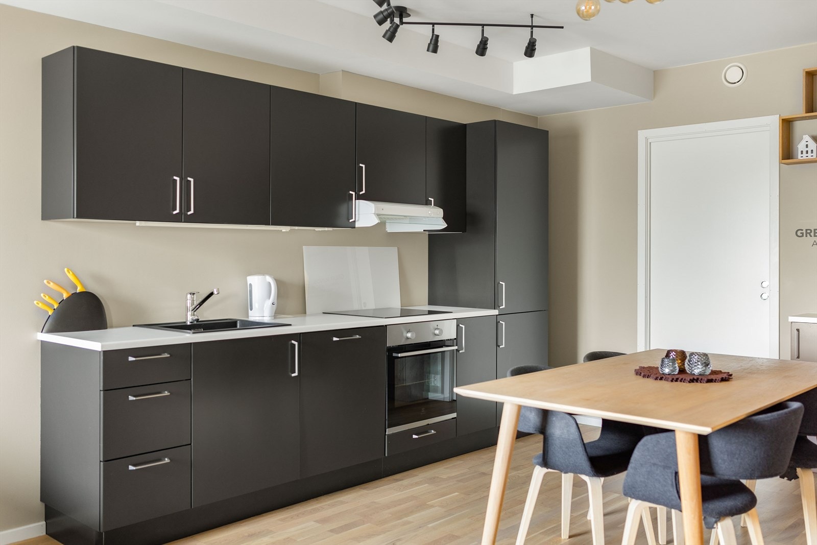 Strai kjøkken med stilig mørke fronter og mye skuff- og skapplass. Kjøkkenet er utstyrt med integrert kjøleskap, induksjon platetopp, stekeovn og oppvaskmaskin. Galleribilde