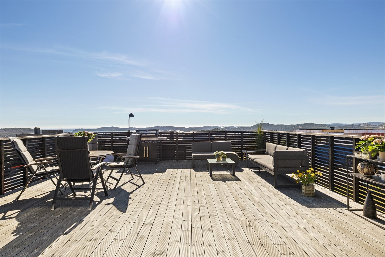 Solen skinner mykt, og en lett bris sørger for at temperaturen er behagelig. Komfortable sitteplasser og et stort bord gir plass til alle, og det er enkelt å bevege seg rundt for å prate med hver enkelt gjest. Galleribilde