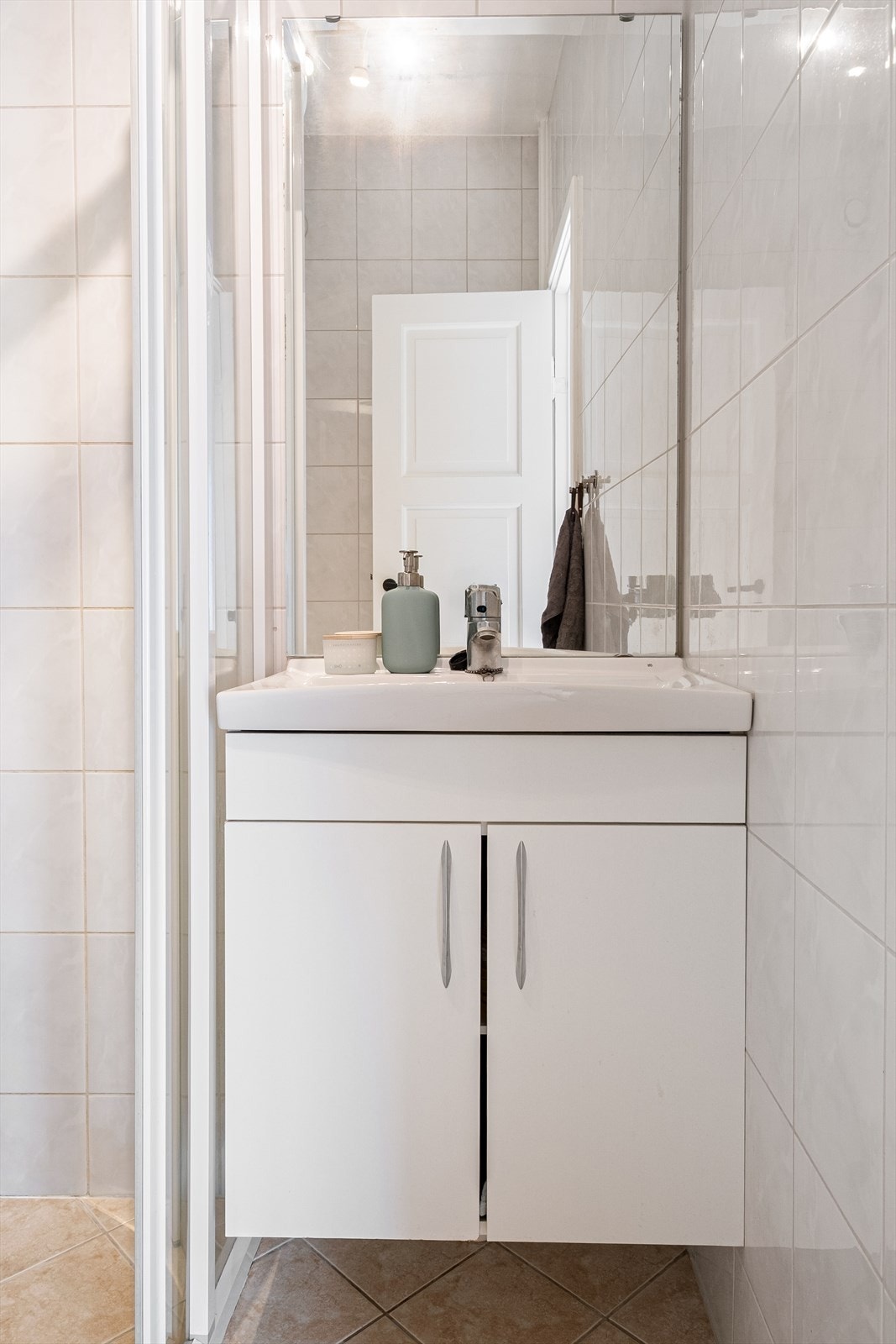 Innredet med klosett, servant på innredning og dusjhjørne med skyvbare glassdører. Galleribilde