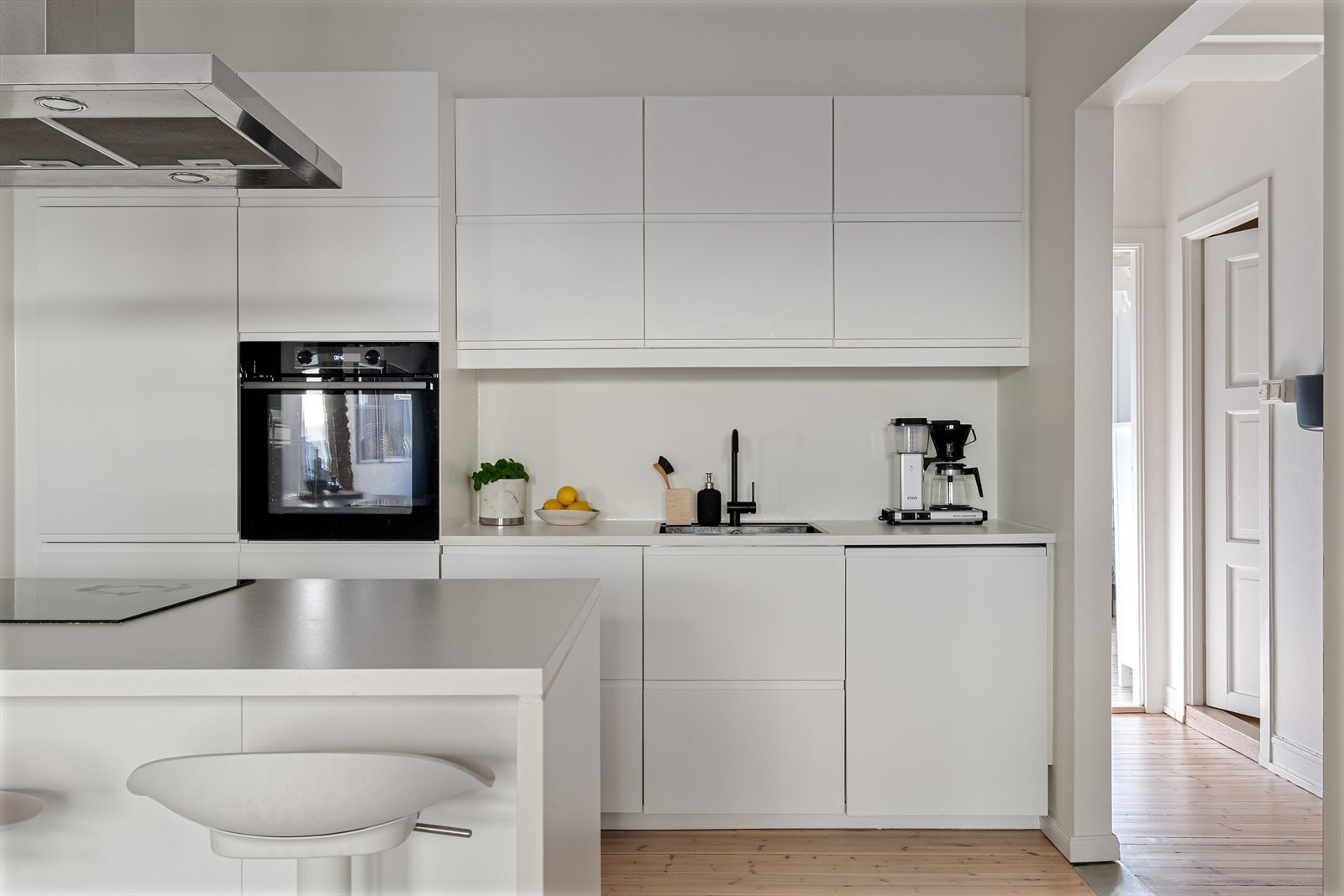 Moderne kjøkkeninnredning med glatte fronter laminat benkeplate med nedfelt vask, integrert platetopp, stekeovn, oppvaskmaskin og kjøl/fryseskap. Galleribilde